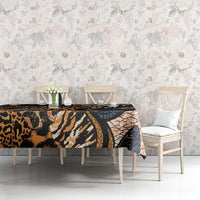 Dining table covered with animal-skin print tablecloth in black, tan, orange, and blue