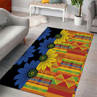 Rectangular black kitenge-style area rug with large yellow/blue floral print and geometric blocks
