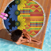 150cm round beach blanket laid flat, black base with colorful floral kente blocks and fringe