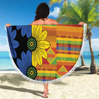 150cm round beach blanket held up on beach, black base with bold blue yellow floral kente design