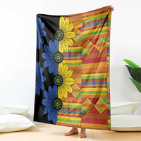 Kitenge-style blanket with large blue and yellow flower print on black and multicolor squares