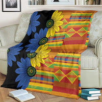 Patterned kitenge-style blanket featuring blue and yellow flowers over multicolor check and stripes