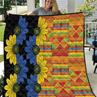 Black quilt with large blue and yellow daisy flowers and colorful patchwork stripes
