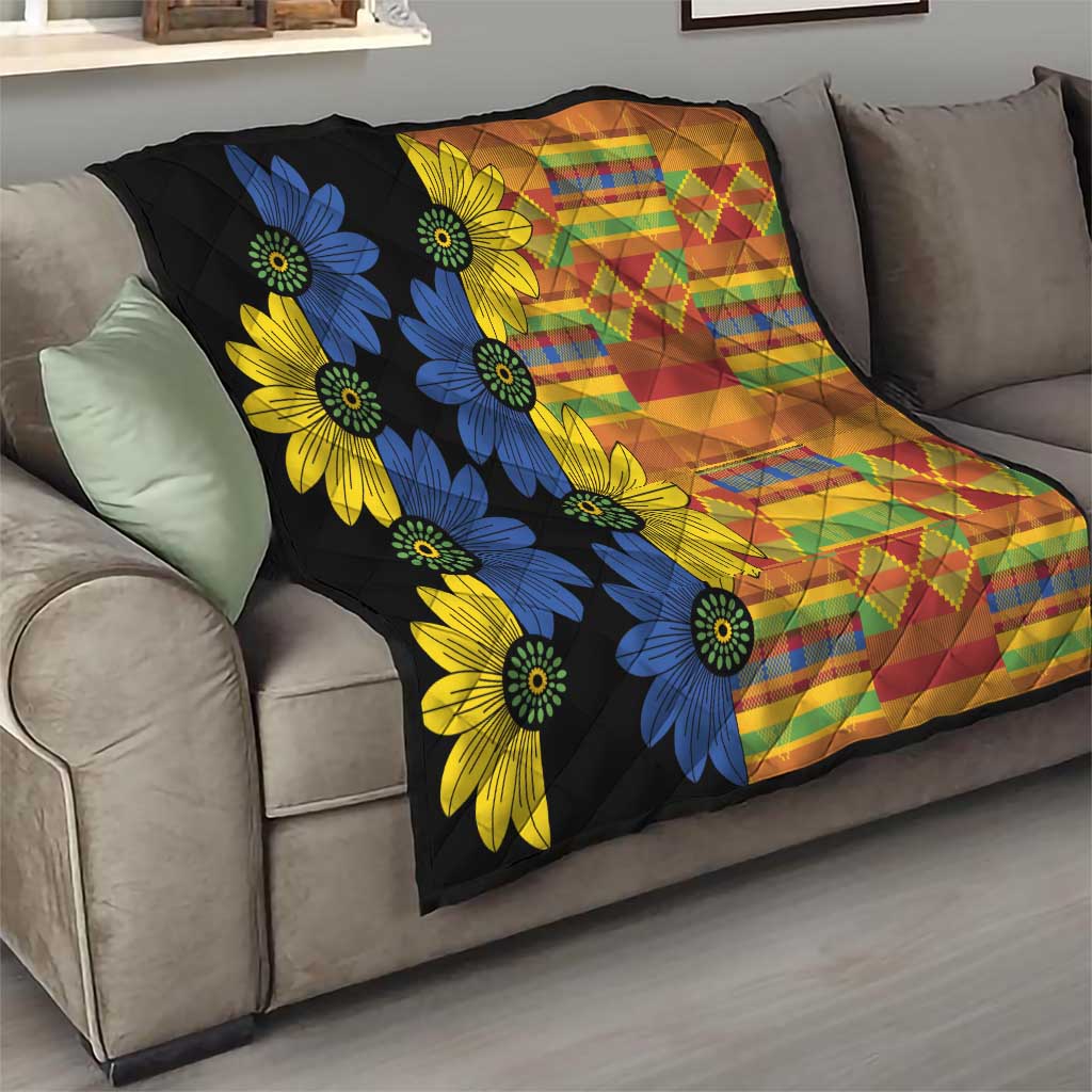 Black quilt on a couch with bold blue and yellow flowers and multicolor diamond stripes