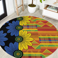 Round kitenge-style carpet, black base with yellow, blue flowers and geometric blocks