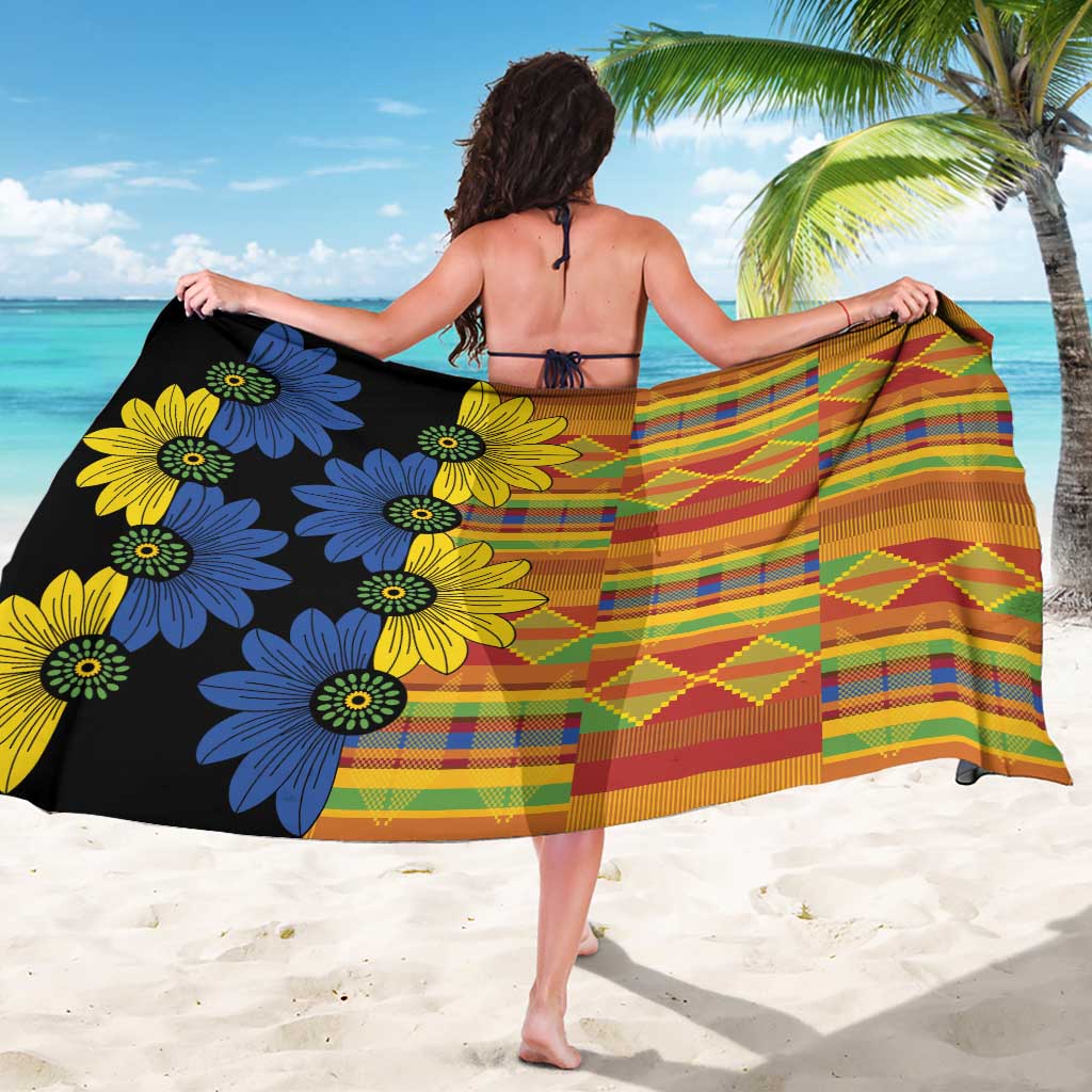 Black kitenge sarong worn as a wrap skirt, multicolor grid stripes and flower motifs