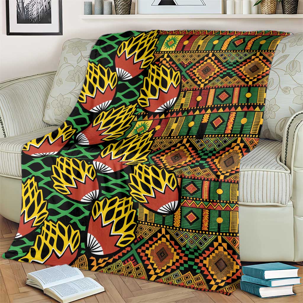 Geometric kanga-style blanket in black with green, red, orange, and yellow accents