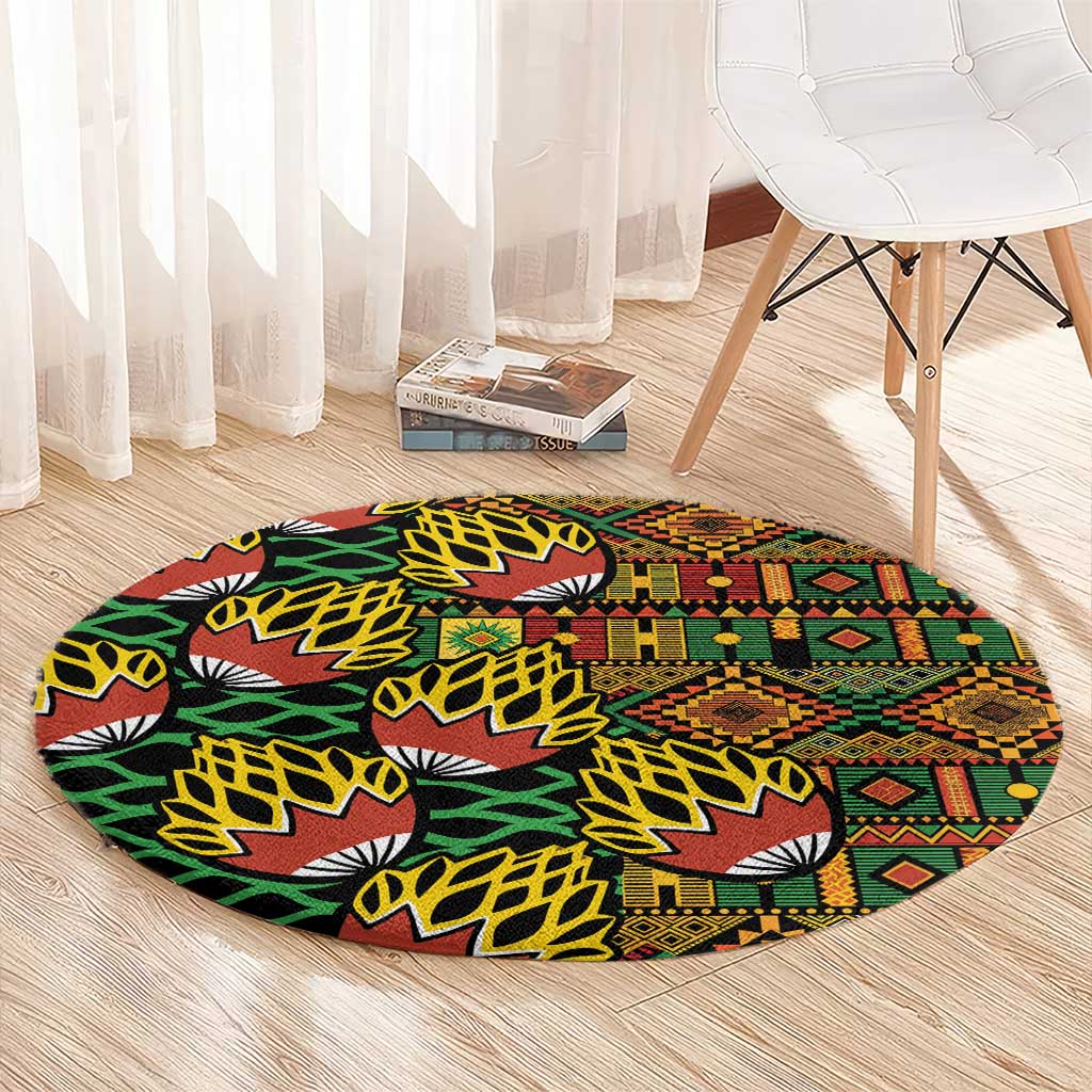 Round kanga pattern carpet on light wood floor, black with green, red, and yellow motifs