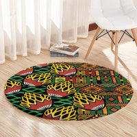 Round kanga pattern carpet on light wood floor, black with green, red, and yellow motifs