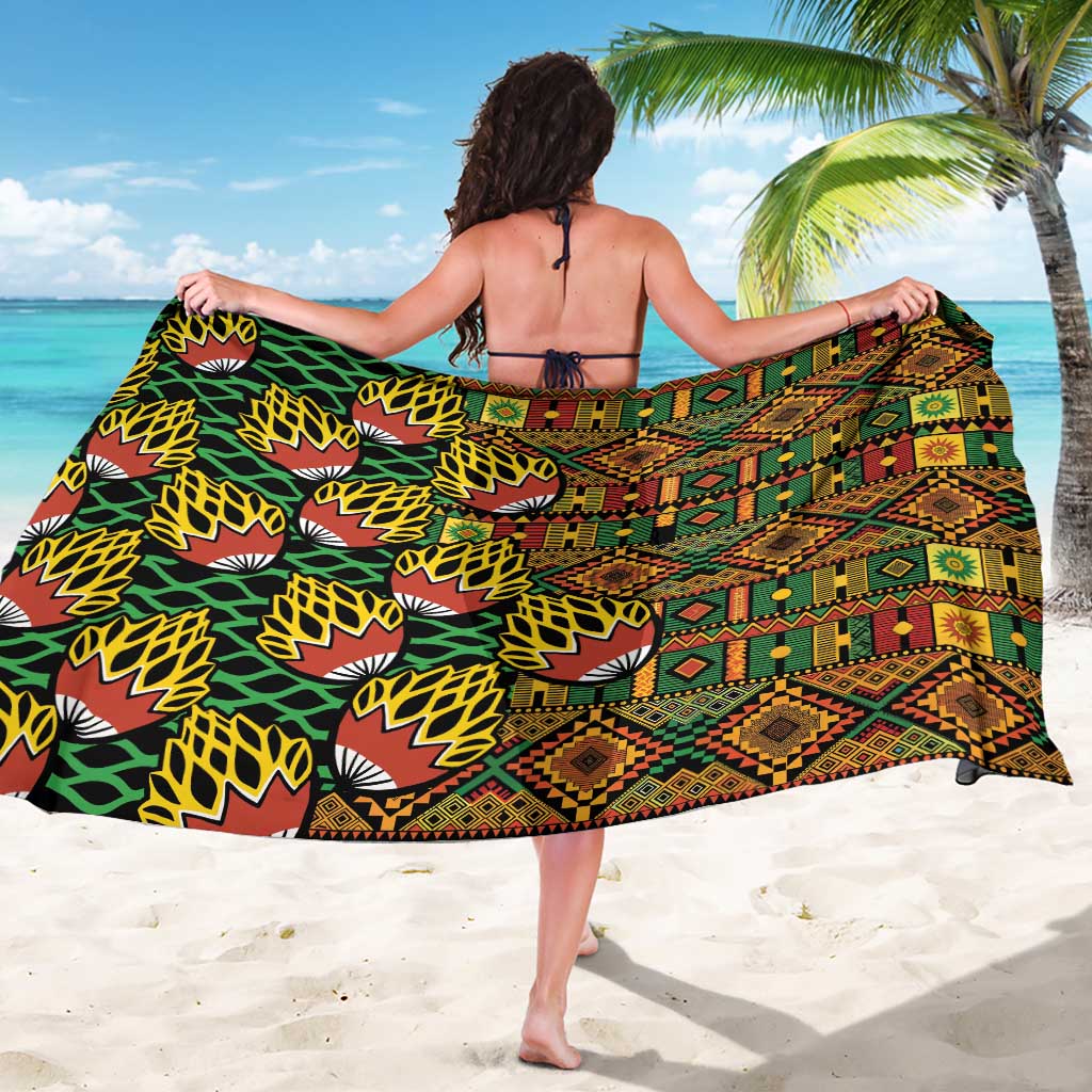Geometric kanga-pattern sarong draped across back, green and black with red-yellow blocks