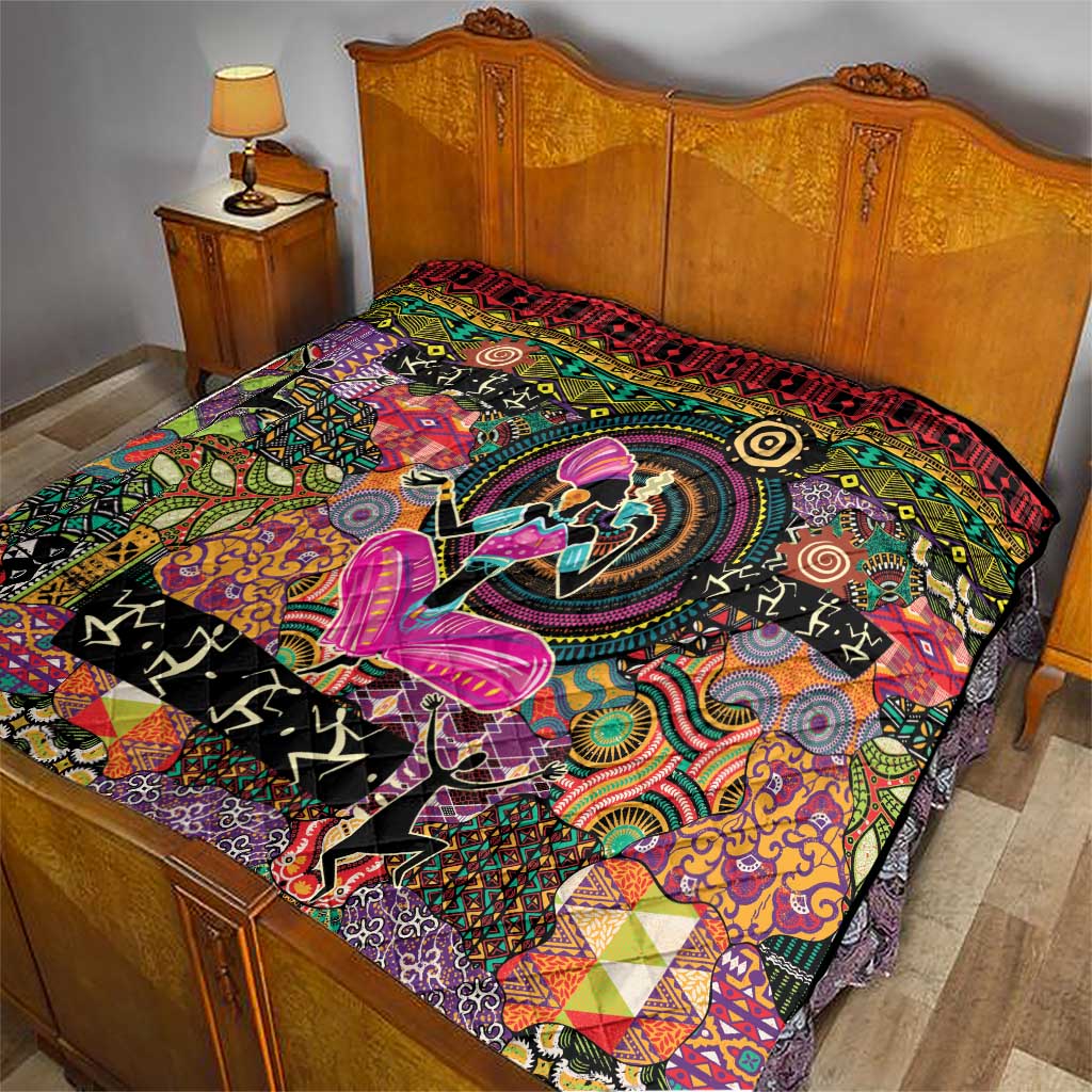 Black quilt on wooden bed with multicolor swirls, tribal shapes, and red patterned edge