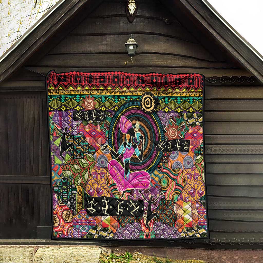 Black quilt hanging outdoors with red border, circular emblem, and purple butterfly motif