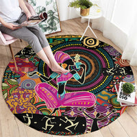 Round black area rug featuring vibrant African-style figures and tribal border motifs