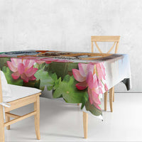 Lotus-themed tablecloth with pink blooms and green leaves draped over wooden dining table