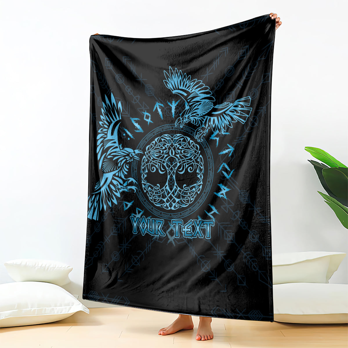Black blanket with blue raven graphic and customizable text, draped over seating