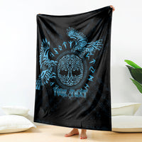 Black blanket with blue raven graphic and customizable text, draped over seating