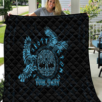 Black quilt with blue raven skull artwork, laid out on patio