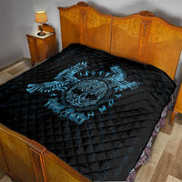 Black quilt with blue raven skull graphic on a bed, diamond-quilt stitching