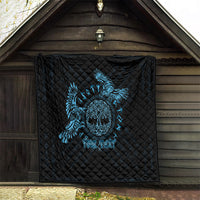 Black quilt with blue raven skull graphic, displayed on wooden porch