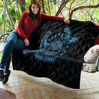 Black quilt with blue raven skull design draped over couch, diamond quilting