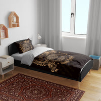 Black and gold duvet cover with raven emblem and one patterned pillow