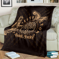 Personalized black blanket with gold raven and circular Celtic knot, draped on chair