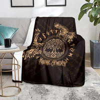 Personalized black throw blanket with gold raven and 'Your Text', on gray couch