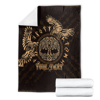 Personalized black blanket with gold raven design and 'Your Text', folded with towels