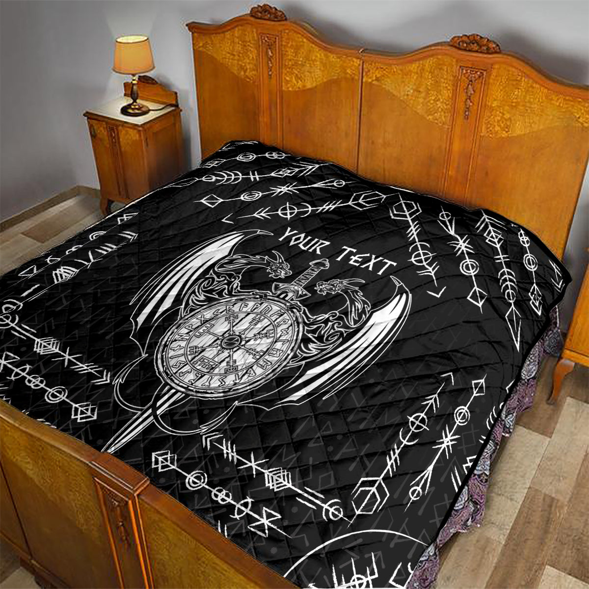 Black quilt blanket on bed with Viking sword-and-dragon emblem and 'YOUR TEXT'