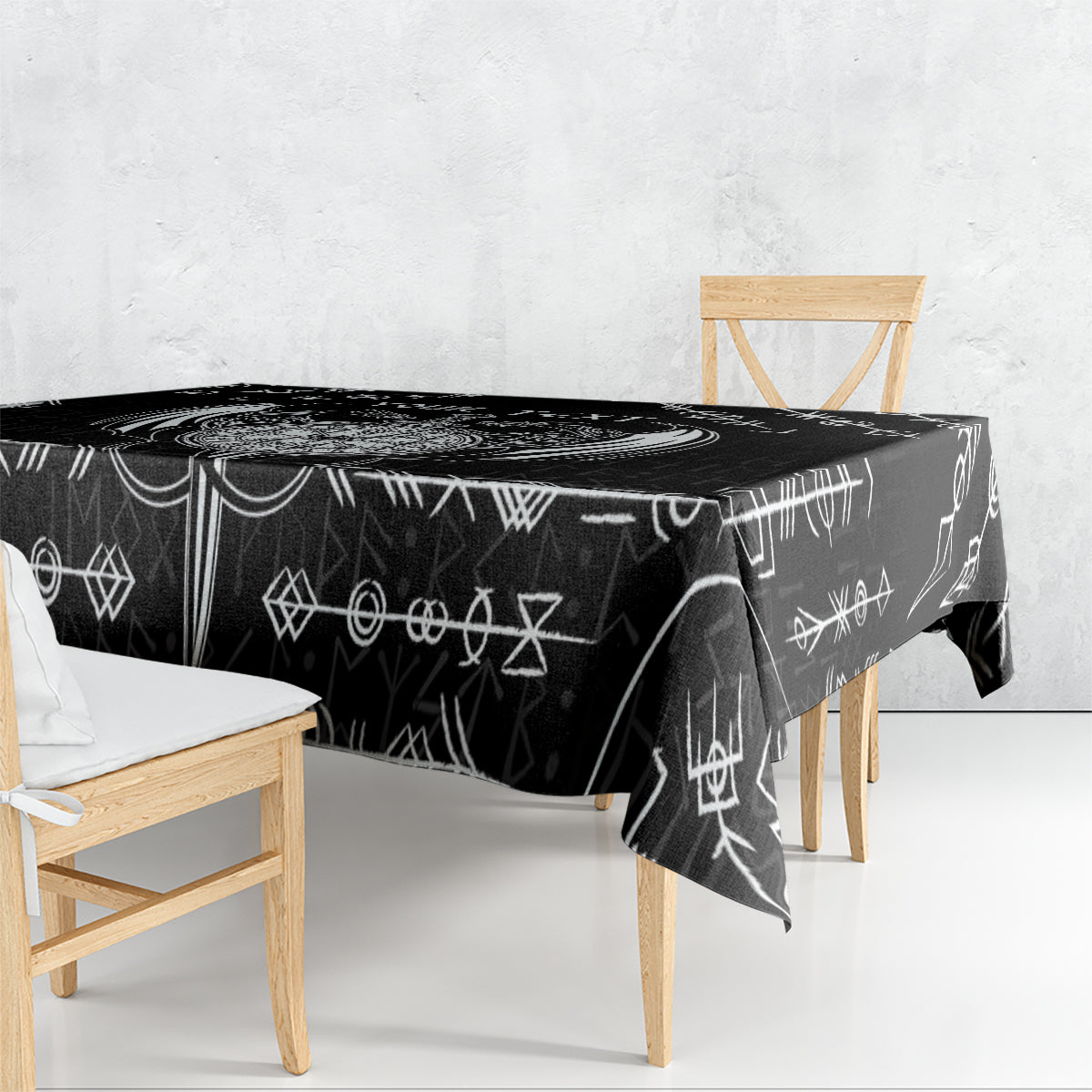 Black tablecloth with repeating white Viking symbol pattern, laid over a table.