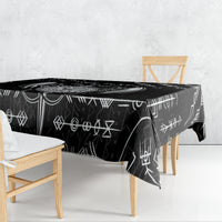 Black tablecloth with repeating white Viking symbol pattern, laid over a table.