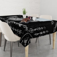 Black tablecloth with white geometric Viking icons, draped to table edges.