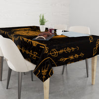 Black tablecloth with gold rune pattern, draped over dining table