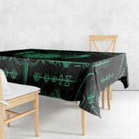 Black tablecloth draped over dining table with green rune symbols and sword motif