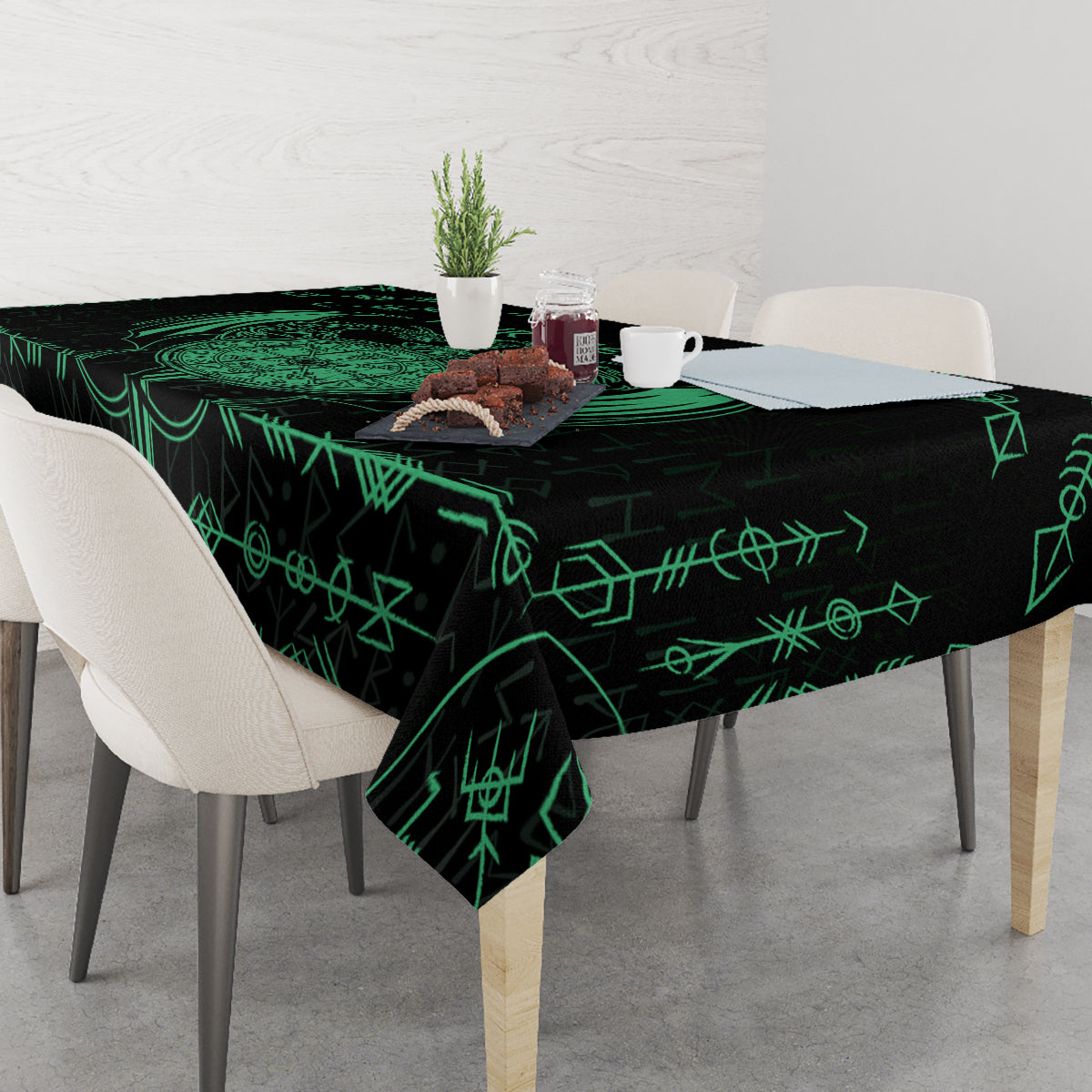 Black tablecloth on dining table with green Viking-style linework symbols across surface