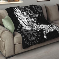 Black quilt draped over sofa with white raven-and-wolf design and rune background.
