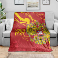Red custom text blanket featuring gold double-headed eagle crest on a sofa throw