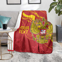 Red custom text blanket draped on table with gold double-headed eagle emblem