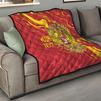 Red quilt with yellow double-headed eagle emblem and personalized text, draped on couch