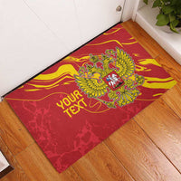 Red rubber doormat with gold double-headed eagle emblem and partial "YOUR TEXT"