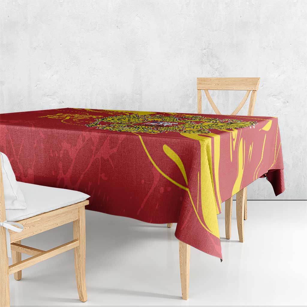 Red tablecloth draped over dining table with gold emblem and decorative borders