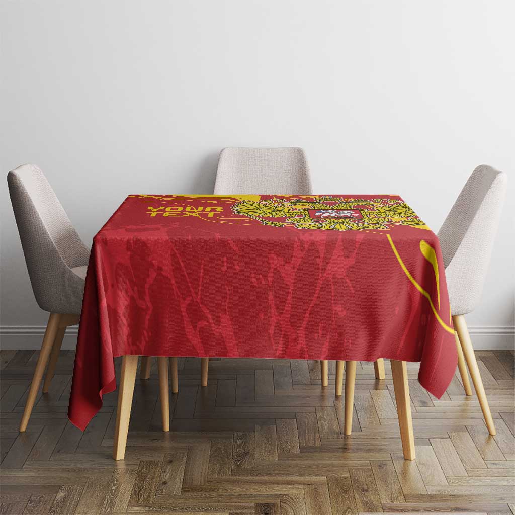 Red tablecloth with gold emblem centered on dining table, draped over edges