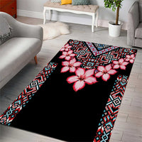 Black floral area rug featuring red blossoms and teal-and-white patterned trim