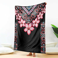 Black floral and tribal pattern blanket with pink flowers and geometric border, draped over surface