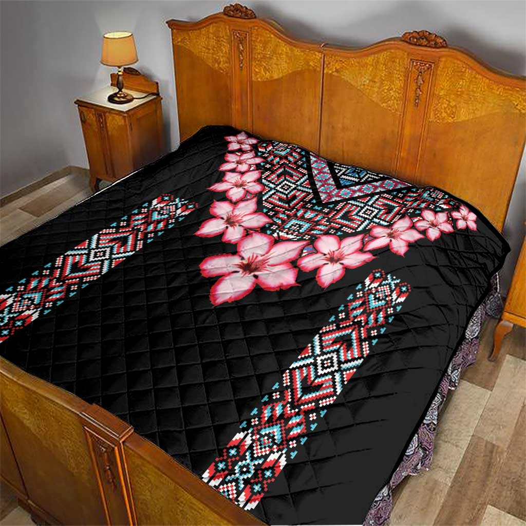 Black quilt blanket with pink floral print and patterned geometric border panels