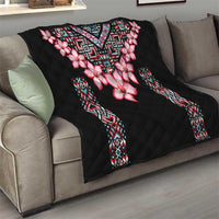 Black quilt blanket with pink floral design and tribal geometric trim on edges