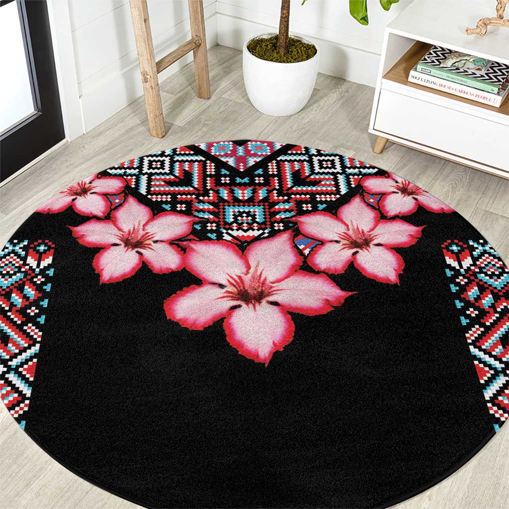 Round black area rug featuring pink hibiscus flowers with multicolor geometric tribal edge