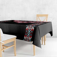Black tablecloth draped over rectangular table with tribal band and red accents
