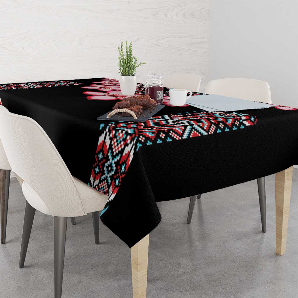 Black tablecloth with tribal pattern runner and red flower details on dining table