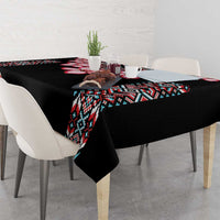 Black tablecloth with tribal pattern runner and red flower details on dining table